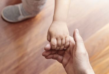Toddler holding adult hand