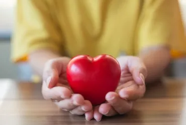 Someone holding a heart shaped ornament